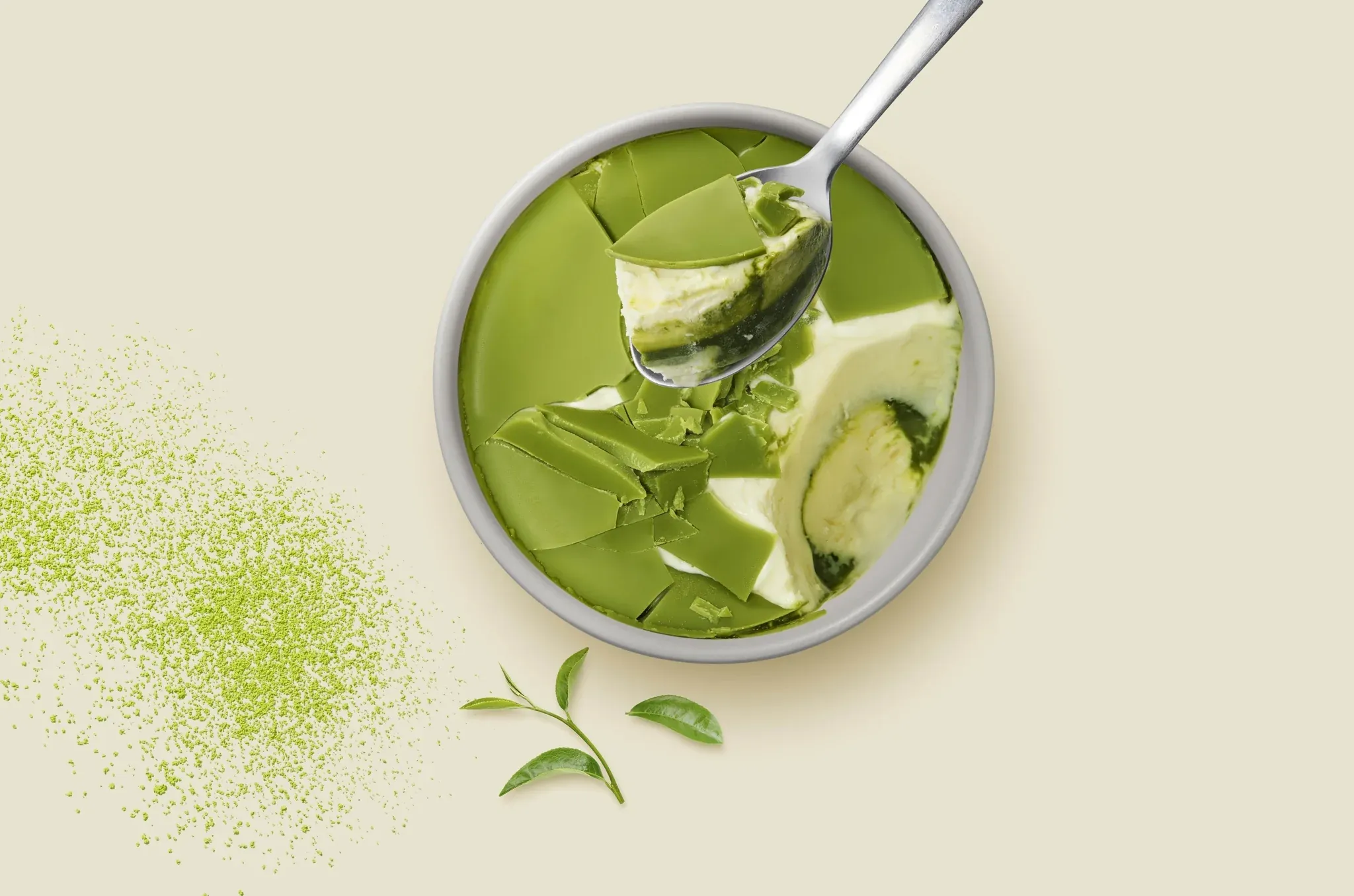 スプーンで抹茶チーズケーキをすくい上げる様子。クリーミーな質感と抹茶パウダー、茶葉が添えられている。
